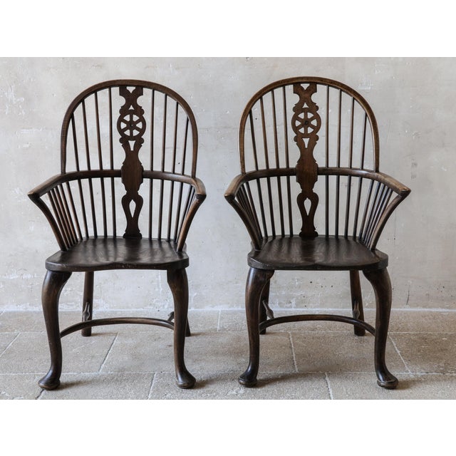 A stunning pair of 18th-century Windsor armchairs, crafted from rich elm wood. These chairs boast a rare and elegant...