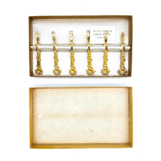 Set of six Florentine gilt hors d'oeuvres and canapé forks presented in their original box. Each fork features a textured...