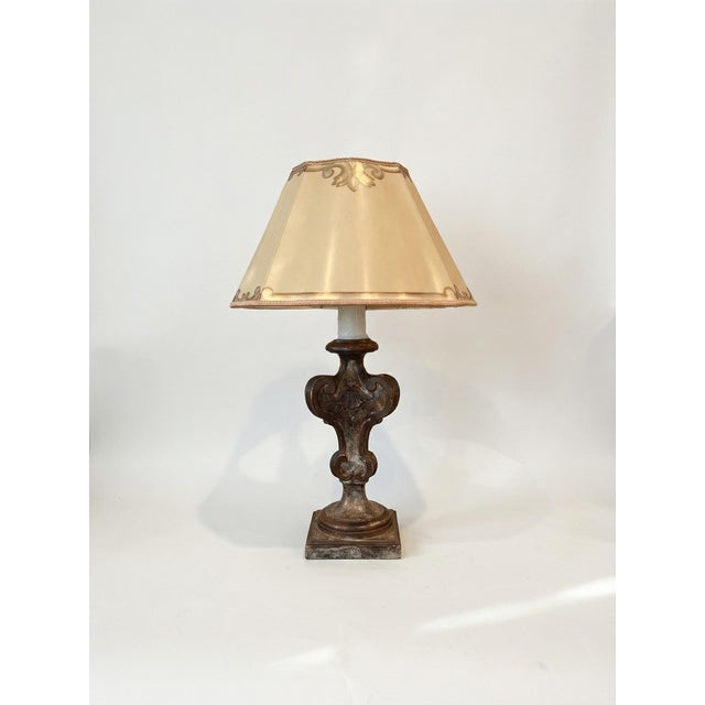 A pair of vintage Dagmar table lamps featuring a sculptural carved wood base with rich patina and classical scrollwork...