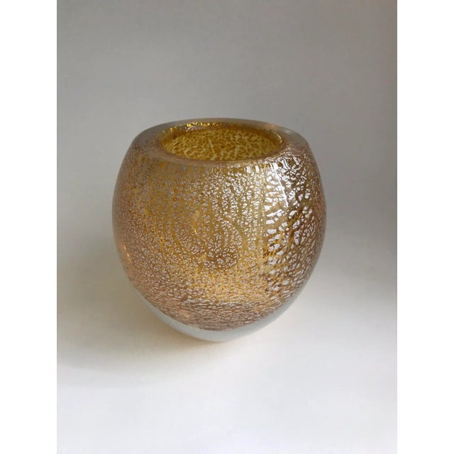 A heavy glass vase of gold / pale amber glass with encased silver foil flecks. It is made in Italy using a centuries old...