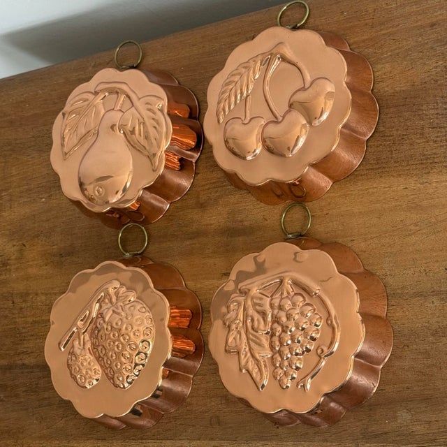 Set of four copper jello molds, each with a different fruit: pear, cherries, grapes and strawberries. Complete with...