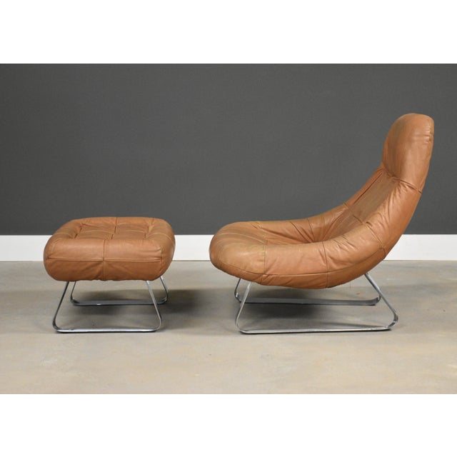 A mid century modern leather Earth Chair and ottoman with chrome sled bases designed by Percival Lafer. Made in Brazil....