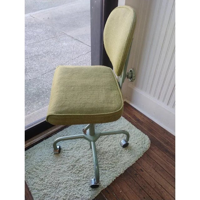 This great 1970s industrial midcentury modern chair on casters has an avocado seat and back with pale green enamel on the...