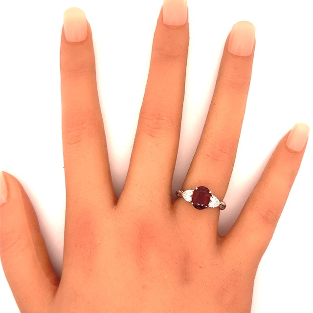 A captivating ruby, weighing 2.64 carats, commands attention at the center of this elegant ring. The ruby's deep red hue...