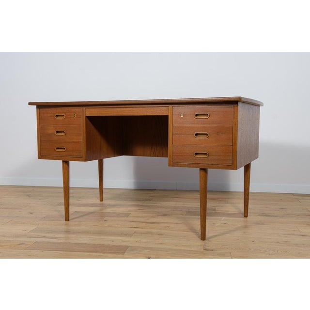 This desk made in Denmark in the 1960s. The desk is made of teak wood and is free-standing thanks to the finished back...