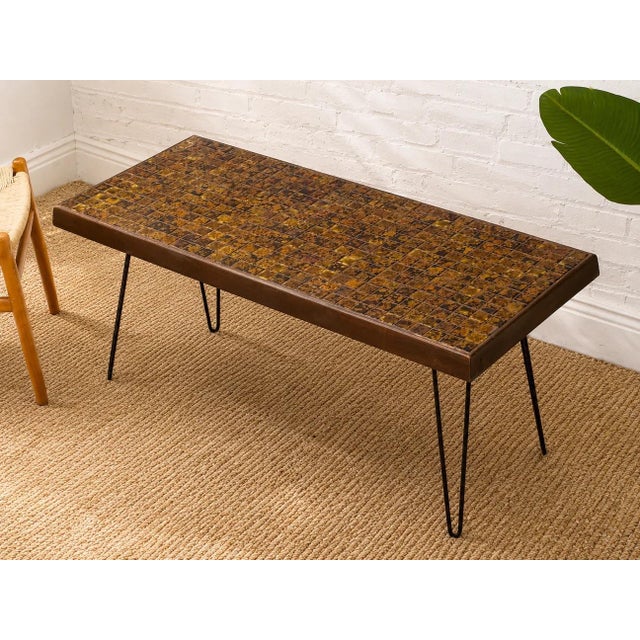 A distinctive vintage console table featuring a richly patterned mosaic tile top set within a slim wood frame and...
