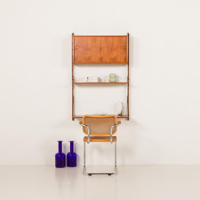 This minimalistic Scandinavian wall unit in teak comes from Norway from the 1960s. It is a completely modular shelving...