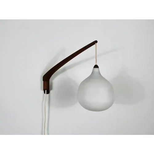 This elegant wall lamp, designed by uno & östen kristiansson for luxus sweden in the 1960s, epitomizes mid-century modern...