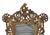Early 20th century Rococo Revival tabletop cast iron mirror with cherub and shell motifs in an antique brass finish....