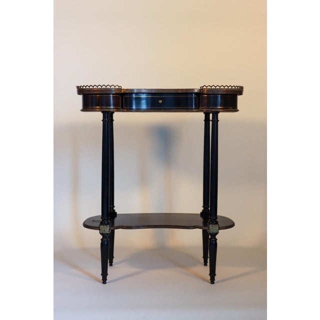 Late 19th Century. the three-quarter gallery around a shaped kidney-form top with gilt-metal inlay, over a medial shelf,...