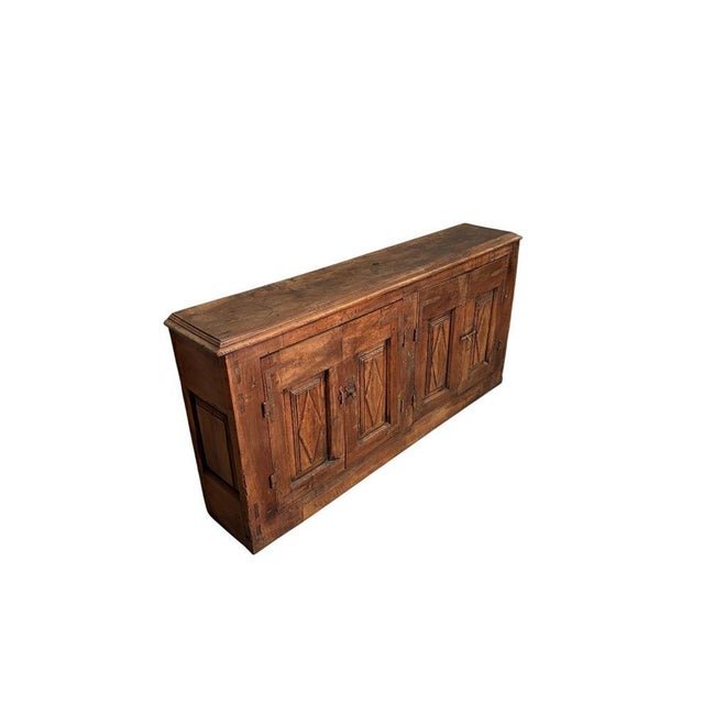 An impressive 18th-century walnut sideboard, featuring diamond-paneled doors and paneled sides. The quality of...