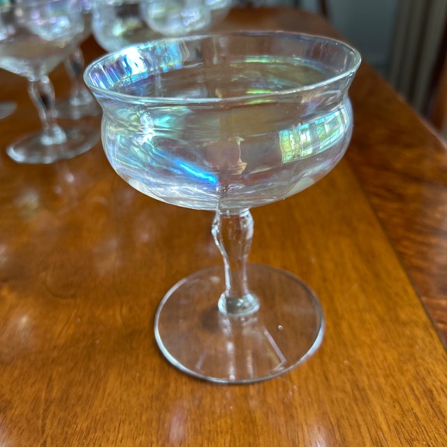 A set of vintage stemmed sherbet glasses with a soft iridescent finish that catches the light in pale pinks, golds, and...