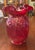 This is a beautiful red art glass vase by Fenton. The vase is decorated with embossed daffodils and has an iridescent...