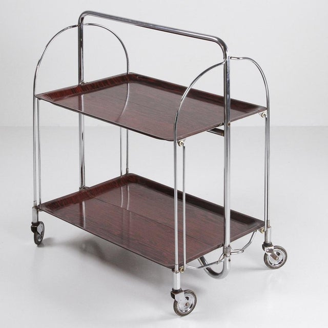 1960s-style Dinette serving cart Made by Gerlinol in Germany in the 1960s. Chrome-plated metal frame and wood-effect...