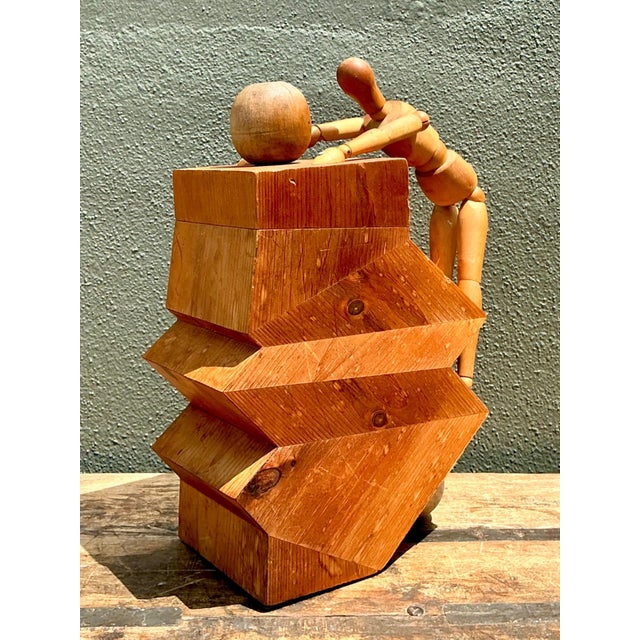 Crafted from wood, this vintage abstract sculpture presents a dynamic interplay of geometric and organic form. An...