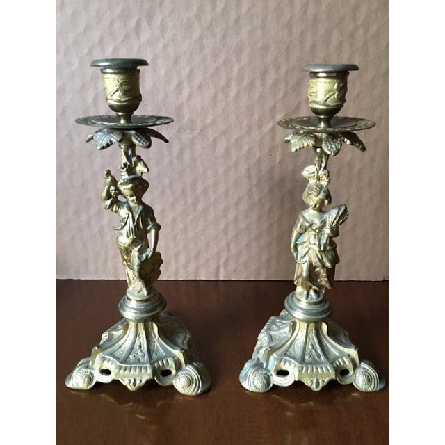 Pair of metal Candlesticks. Male and female figures. These figures represent the two seasons of Summer and Winter. The...