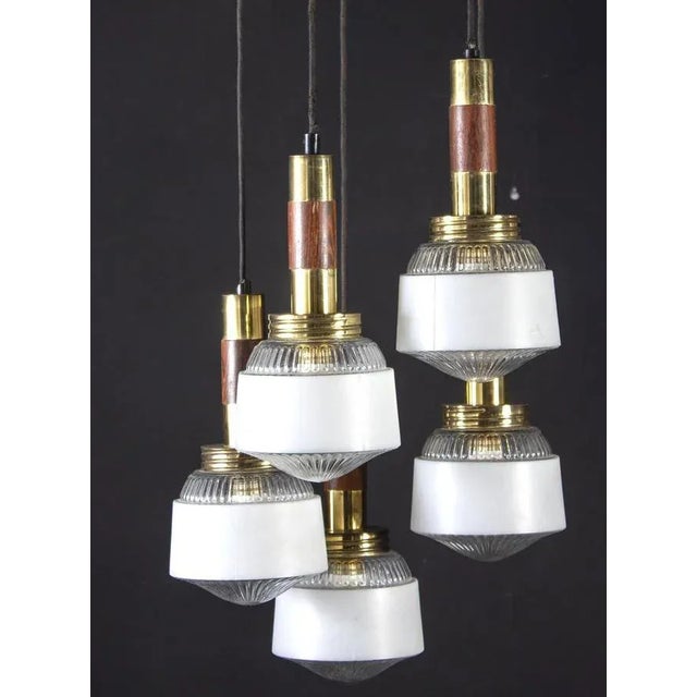 Modern wood and brass cascade chandelier with five glass cup. Five E 14 light bulbs. Up to 250V (Europe/UK Standard).The...