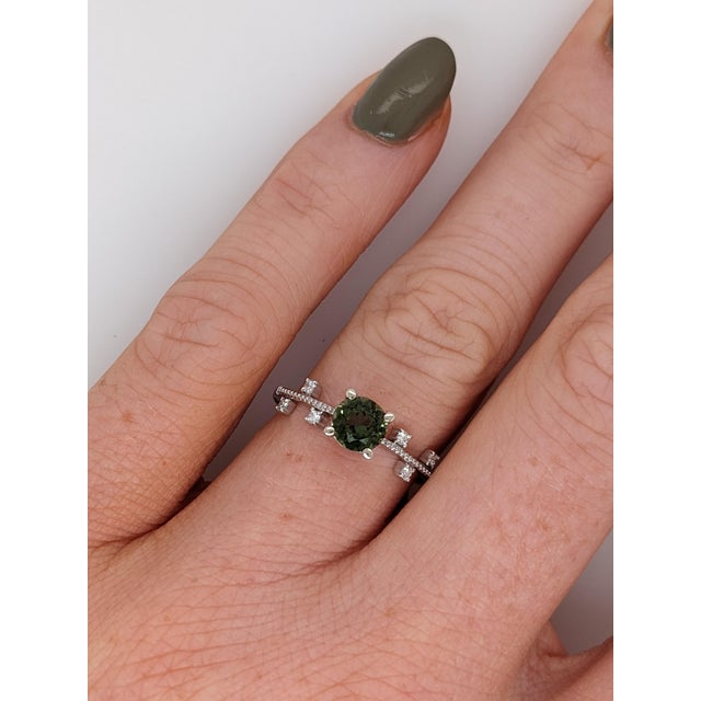 A green tourmaline takes centre stage in a fresh green at the centre of this solid 14K white gold ring, surrounded by six...