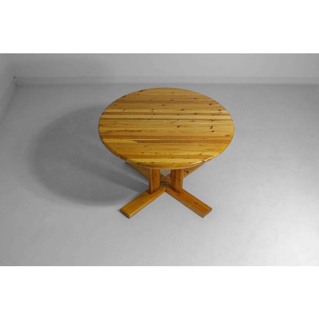 This dining table by Rainer Daumiller is made of solid pine and can change from a round to an oval shape when extended....