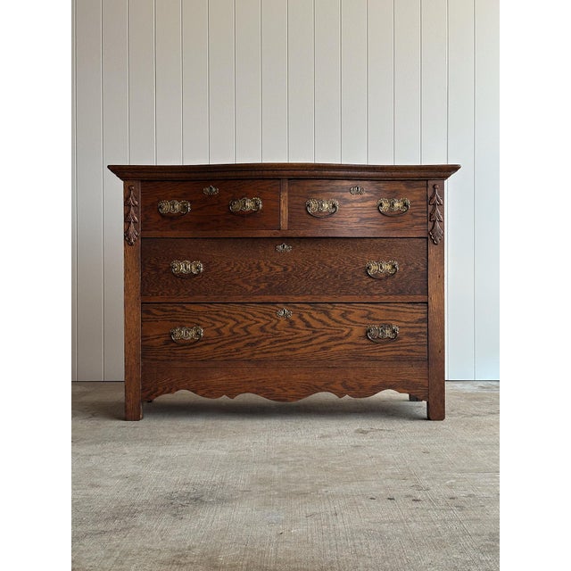 Antique oak chest of drawers with a softly bowed serpentine front. Two-over-two drawer configuration with original brass...