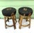 Pair of vintage rattan counter stools featuring dark green upholstered seats with embroidered birds, foliage, and Asian-...
