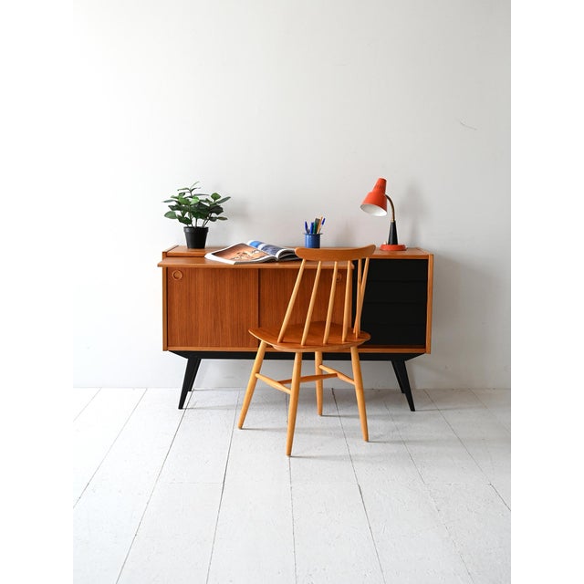 1950s/60s teak sideboard with black legs and drawers, pull-out desk, sliding doors, and internal storage. Original...
