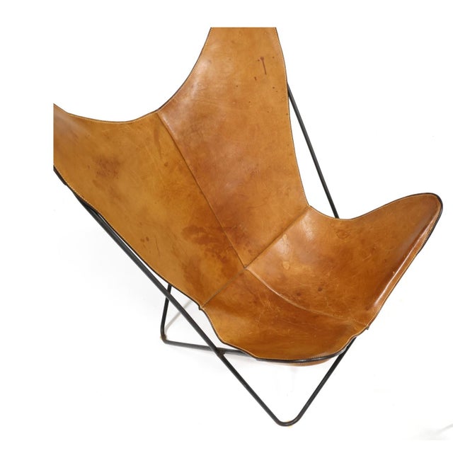 Circa 1980, black painted iron stationary frame with stitched tan leather slings, leather sling stamped "Cow Catcher,...