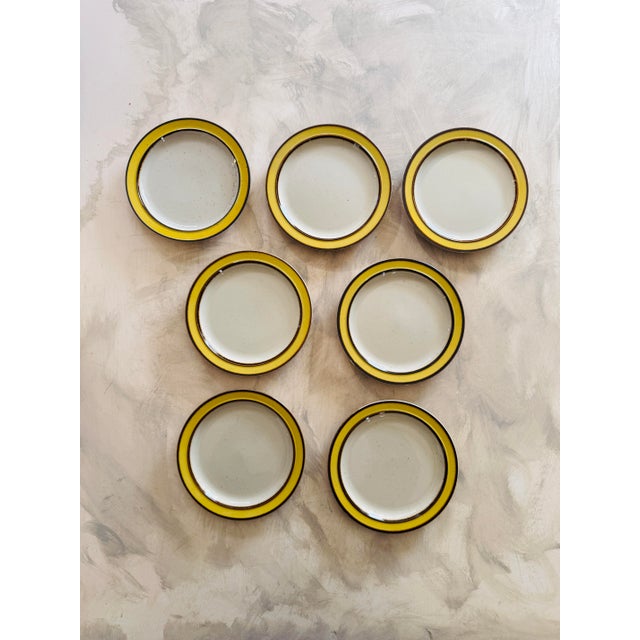 This is a set of seven vintage Rainbow Stoneware plates in the cheerful and highly collectible Citron pattern, made in...