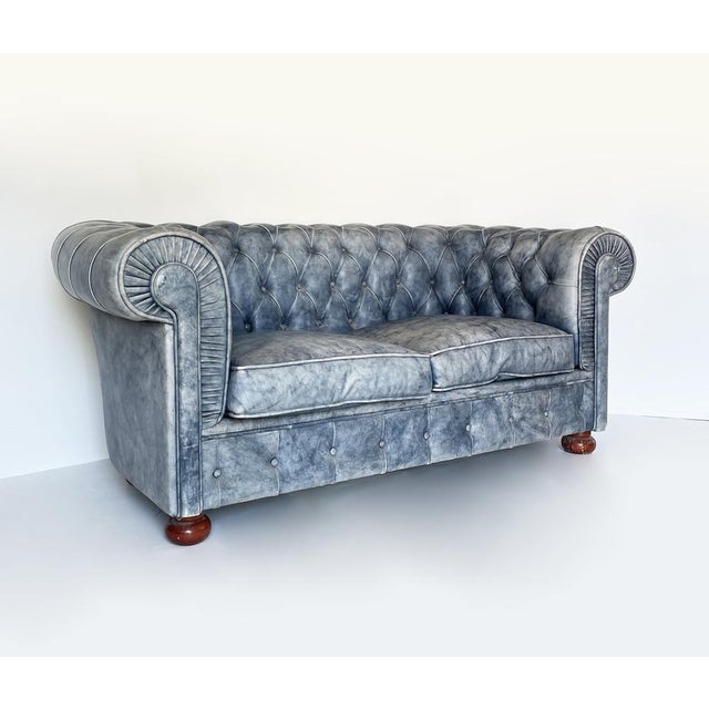 Chesterfield 2-seater sofa in vintage-effect leather, featuring elegant button-tufting, rolled armrests, and a faded gray-...