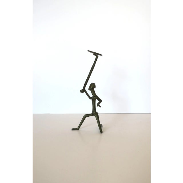 A small bronze male tribal warrior figure sculpture piece, in the style of Hagenauer, Tribal style, circa 20th century. A...