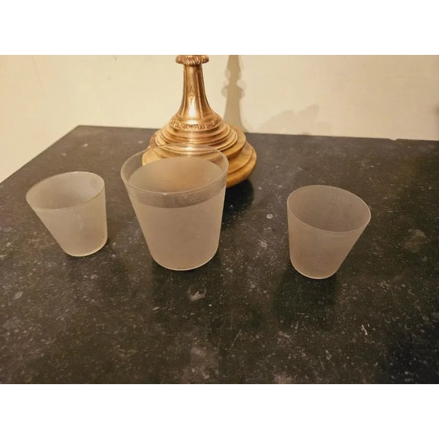 Cigarette display in chopped brass and gilded bronze resting on a molded socle in siena yellow marble, with 3 satin...