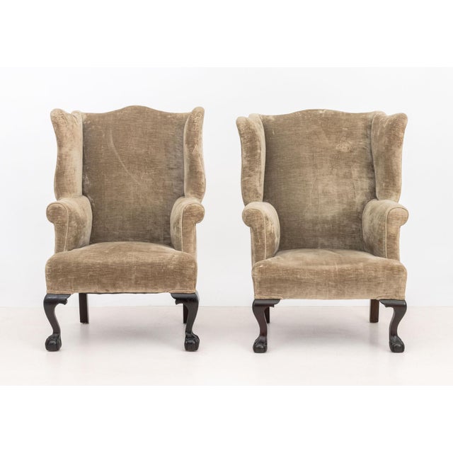 Pair of George III Style Upholstered Wingback Arm Chairs, on ebonized claw and ball feet. 44.5" H x 27" W x 26" D; seat:...