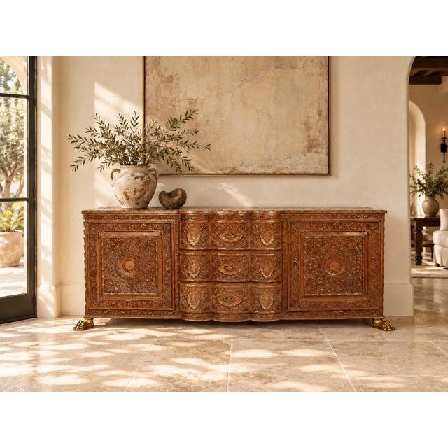 An exceptional 19th-century Javanese hand-carved wooden sideboard from Indonesia, featuring elaborate floral relief...
