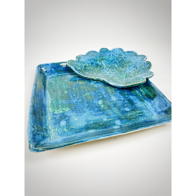 A striking handmade studio pottery serving set featuring a 13-inch square platter paired with a sculptural scalloped bowl...