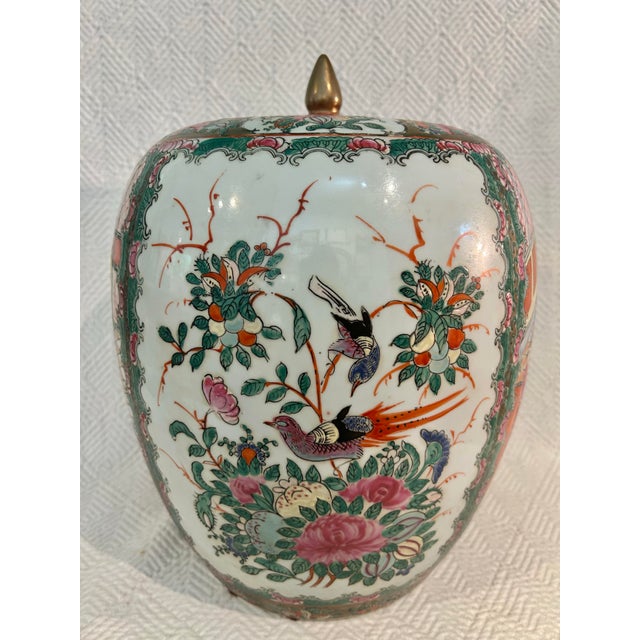 This is a large-scale Chinese Famille Rose ginger jar featuring richly detailed court scene decoration framed by floral...