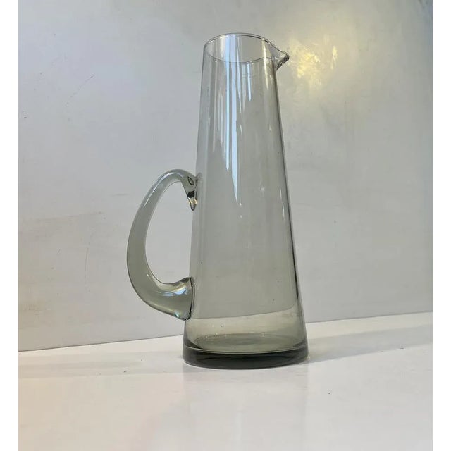 Elegant hand-blown pitcher in grey smoke glass designed by per Lütken circa 1960 and made Holmegaard in Denmark....