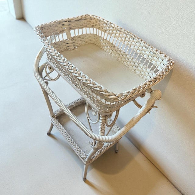 Charming vintage 1940s wicker stand featuring a woven basket top and lower tray shelf — perfect for displaying plants,...