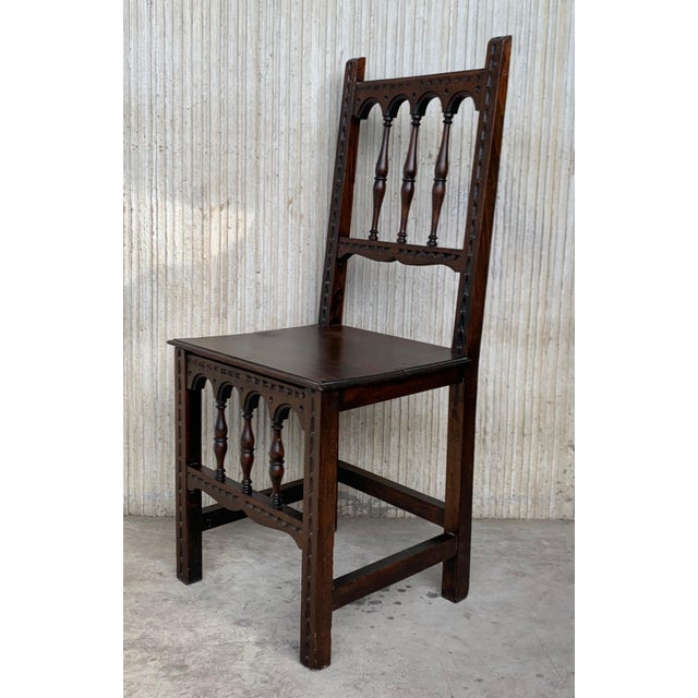 A set of 4 Spanish chairs with wood seat on walnut and sycamore frames with hand carved decoration. These chairs are true...