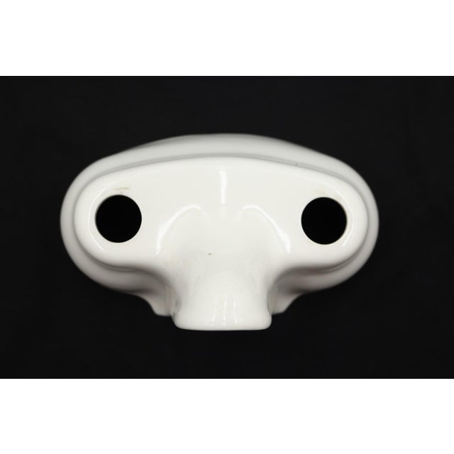 Reclaimed white ceramic faucet cover featuring two circular top openings for hot and cold tap handles, and a central front...