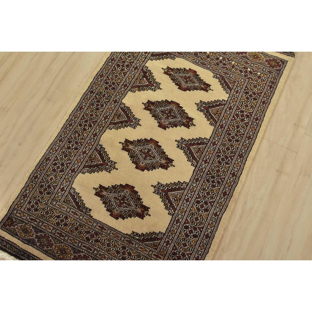 A tribal Bokhara Jaldar rug hand-knotted with fine wool on a cotton foundation. This rug features geometric medallions set...