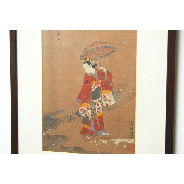 Japanese woodblock print depicting a Japanese woman dressed in a traditional red kimono and a pair of getas, holding an...