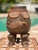 A deeply compelling piece of African material culture, this hand-carved wooden vessel stands on four legs ending in human...