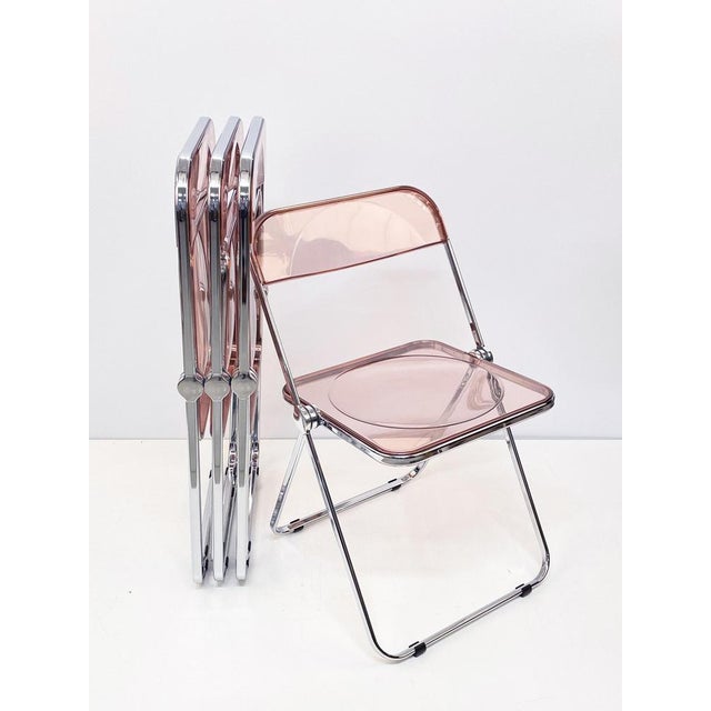 Set of 4 original and signed "plia" pink acrylic glass folding chairs. Nos (new old stock) this fantastic set was designed...