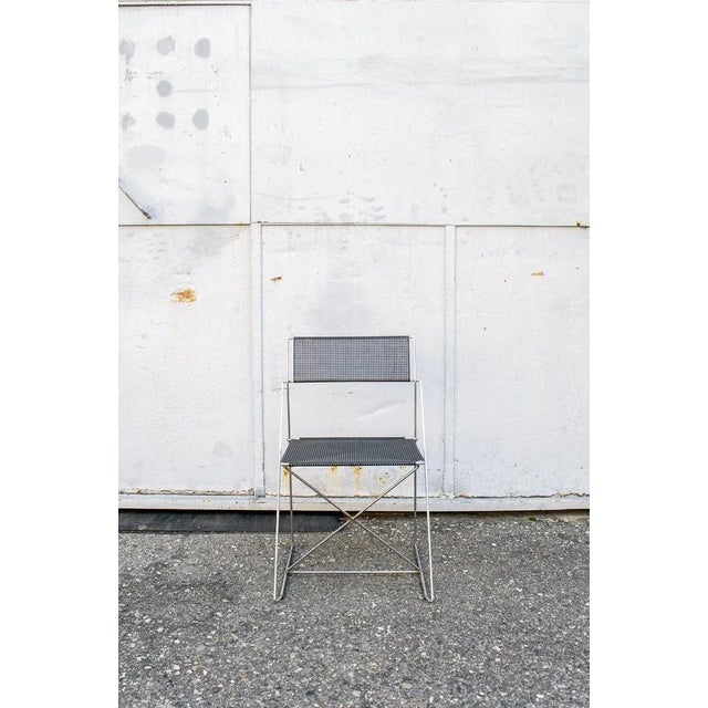 Pair of stackable chairs with chromed metal structure, seat and back in the black lacquered metal network. Model X-Line...