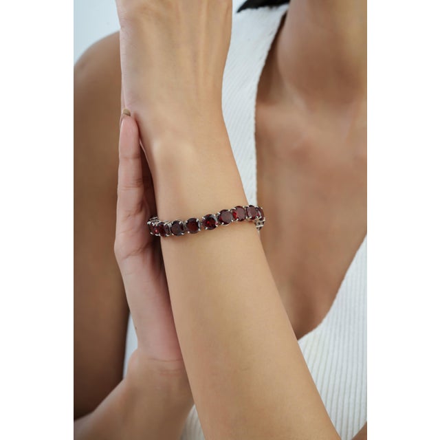 Add a rich touch of color to your jewelry collection with this striking tennis bracelet, featuring an impressive 52.45...