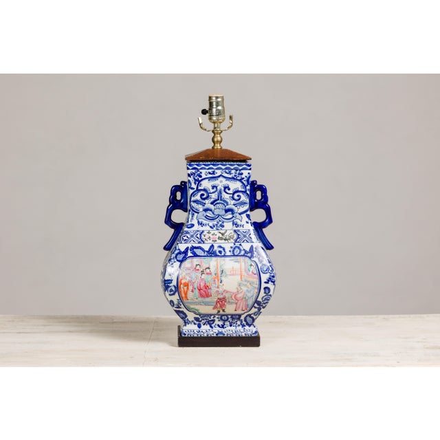 A vintage blue and white porcelain table lamp with colorful hand-painted court scenes on the belly. This vintage blue and...