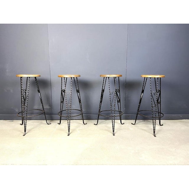 Vintage bar stools made from a round oak seat and a beautiful wrought iron sculpted base with elegant feet. 1960s - France...
