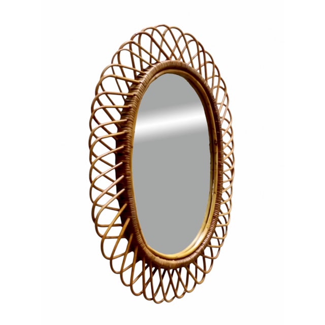 Italian rattan wall mirror (circa 1960s) by Franco Albini. The mirror has a complex weave of rattan in a series of...