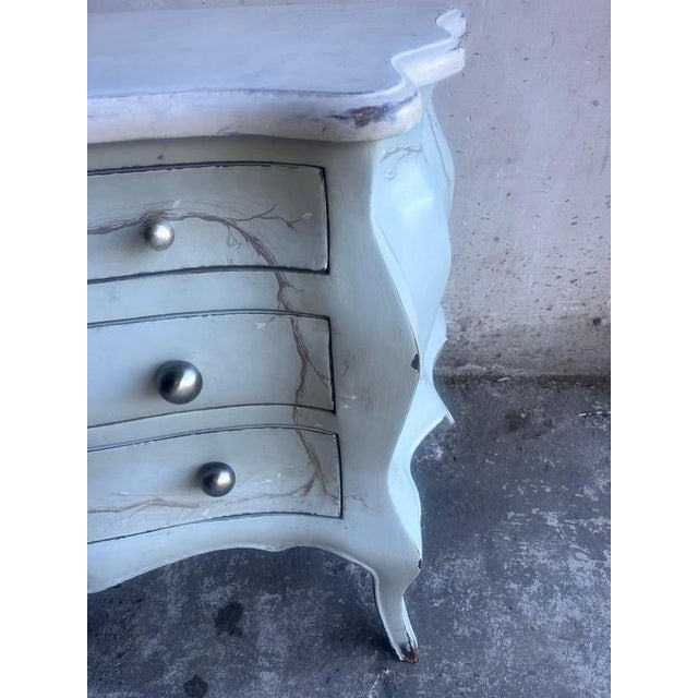 This elegant Rococo-style chest of drawers is distinguished by its graceful curves, hand-painted decoration, and...