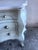 This elegant Rococo-style chest of drawers is distinguished by its graceful curves, hand-painted decoration, and...